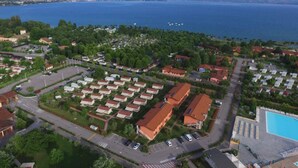 Vista aérea de una zona residencial costera con una extensa masa de agua al fondo.