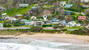 Zona residencial costera con casas, una playa y una carretera.