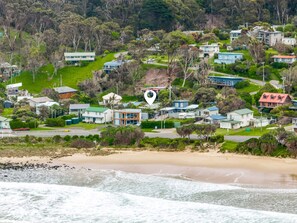 A coastal residential area with houses, a beach, and a road. - The Beach Cottage (Separation Creek)