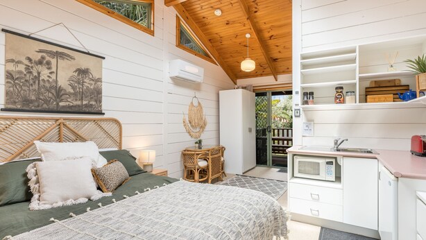 Un dormitorio acogedor con cama, mesita de noche y vistas al exterior.