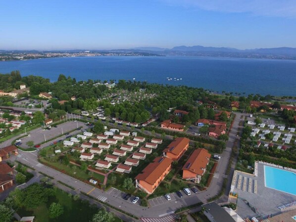 Vue aérienne d’une zone résidentielle côtière, avec une vaste étendue d’eau en arrière-plan.