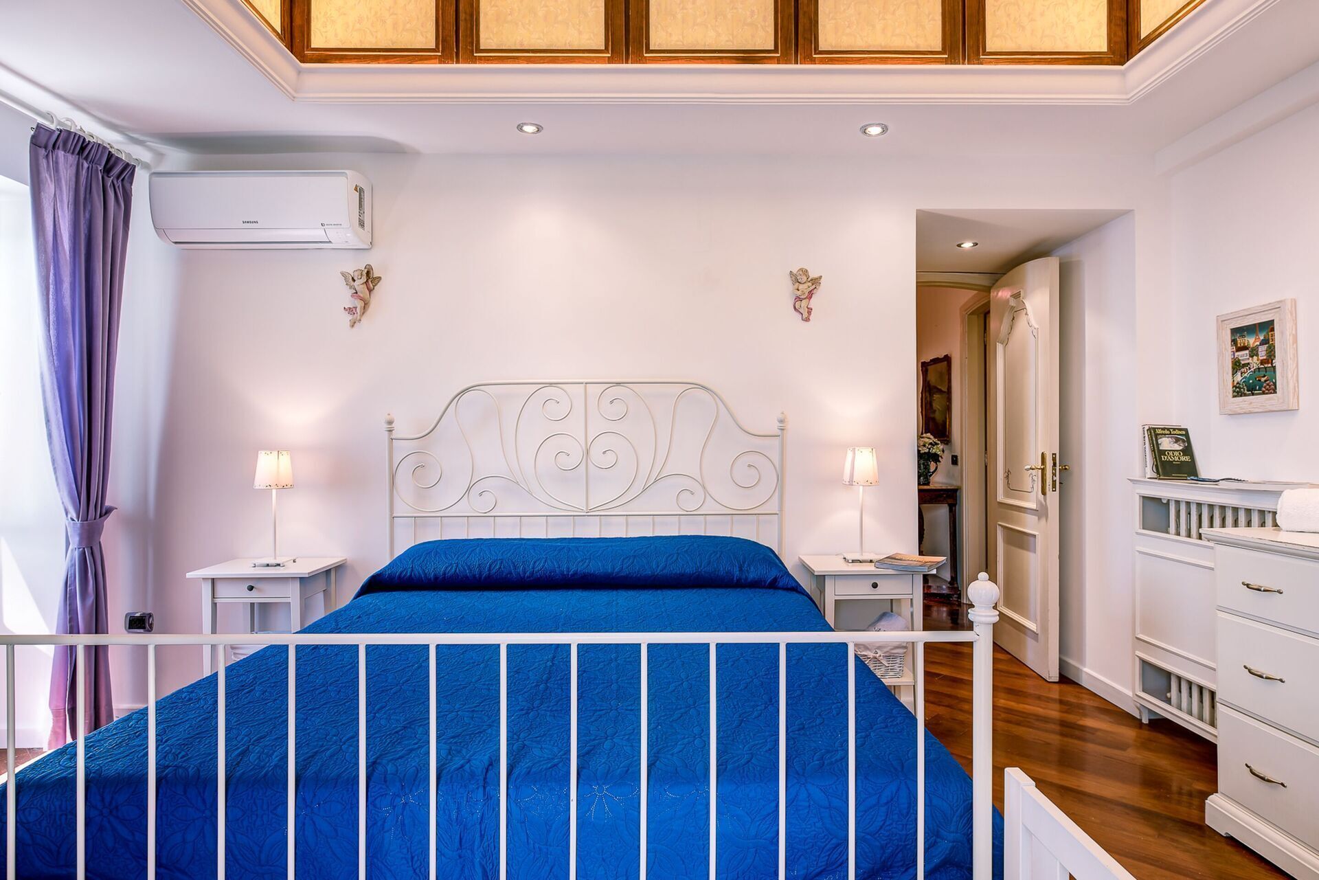 A bedroom with a bed, bedside tables, a wardrobe, and a ceiling fan.