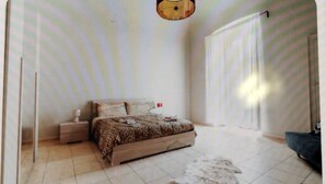 A bedroom with a bed, nightstands, a lamp, and a patterned rug.