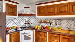 A kitchen with wooden cabinets, a built-in oven, and a tiled backsplash.