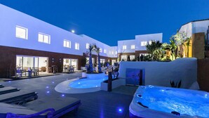 A rooftop pool area with a hot tub, lounge chairs, and a seating area. - 9 Balinese-style Houses with 3 Bedrooms, Communal Pool, and Jacuzzi (Roses)