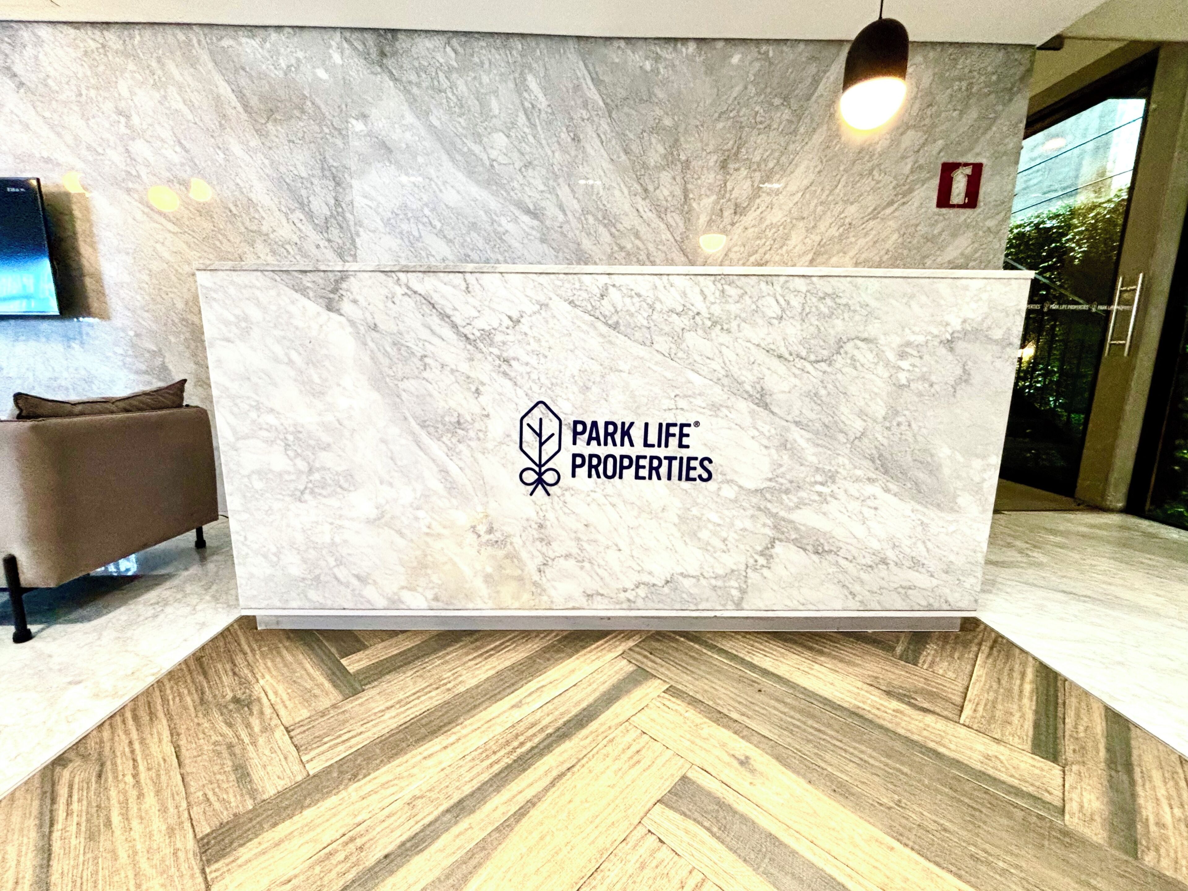 A reception desk with a marble top and a logo for Park Life Properties.