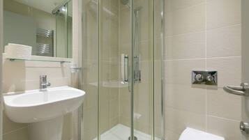 A bathroom with a glass-enclosed shower, a sink, and a toilet.