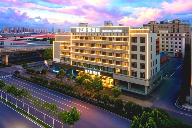 Un hôtel à plusieurs étages doté d’une façade moderne, de nombreux balcons et d’un espace de stationnement à l’avant.