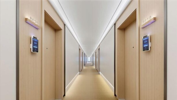 A hotel hallway with a carpeted floor, wooden walls, and illuminated room numbers. - Xinzhiyuan Yue Hotel (Hefei South Station Luogang Central Park) (Hefei)
