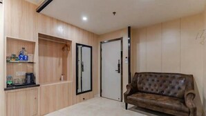 A modern living room with a brown leather sofa, wooden cabinets, and a tiled floor. - Xinzhiyuan Yue Hotel (Hefei South Station Luogang Central Park) (Hefei)