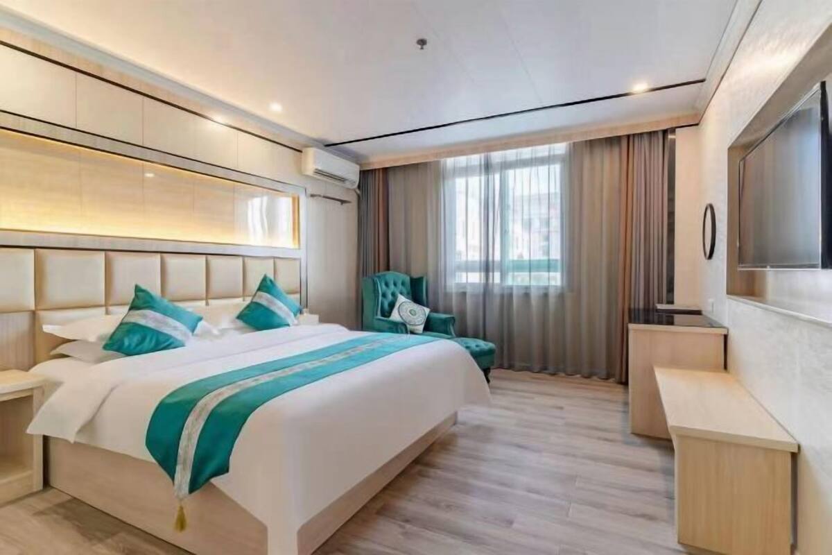 Habitació d'hotel moderna amb un llit gran, un escriptori i una televisió.