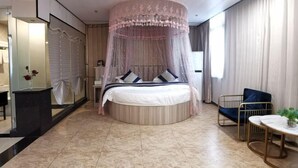 A bedroom with a round bed, a canopy, a bedside table, a chair, and a small table with a plant. - Xinzhiyuan Yue Hotel (Hefei South Station Luogang Central Park) (Hefei)