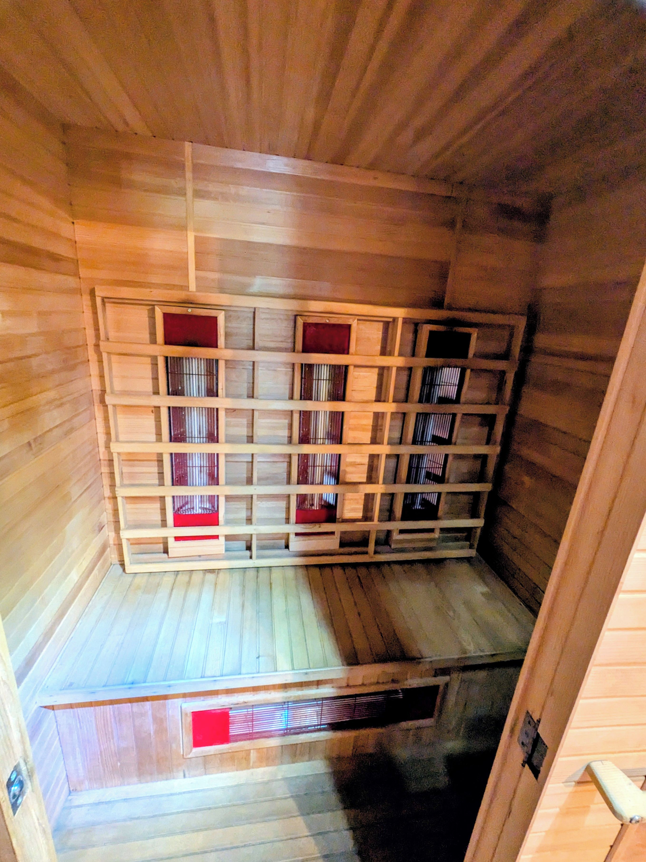 Un sauna avec des murs en bois et un plafond incliné.