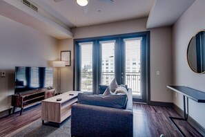 Relax in this inviting living space with a flat-screen TV, comfortable sofa, and large window.