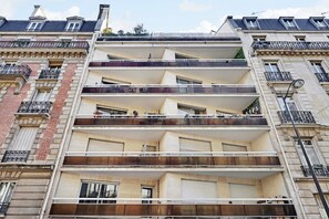 A multi-story building with balconies, large windows, and a classic architectural style.