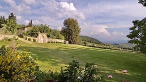A rural landscape with a stone building, a large tree, and a grassy field. - Villa Grassina (Pelago)