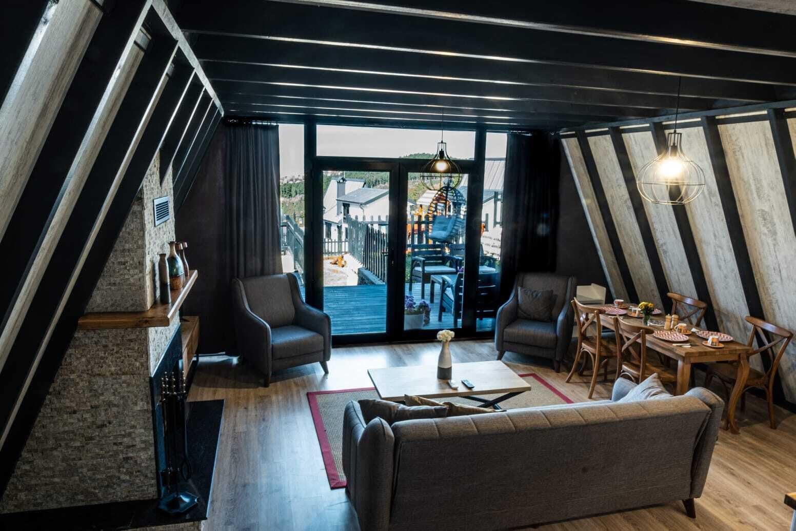 Une chambre moderne de style loft, dotée d’une grande fenêtre, d’un coin repas et d’un espace salon confortable.