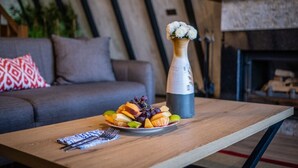 Een eettafel met een fruitschaal en een thermosfles.