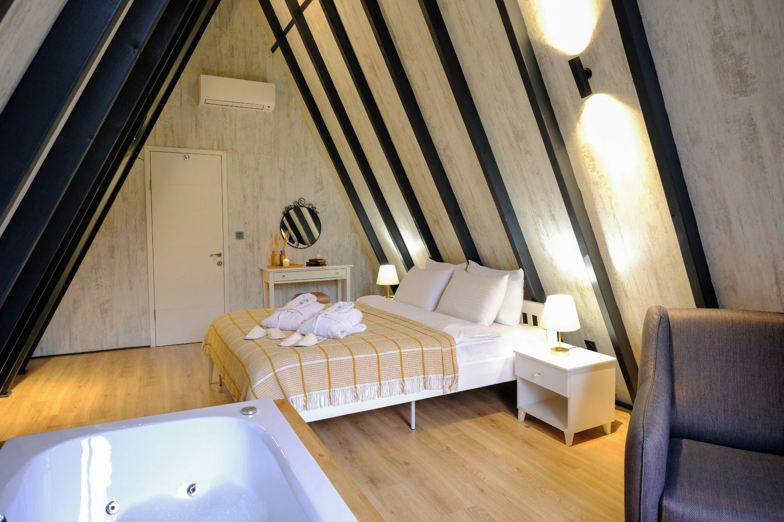 Un dormitorio con cama, mesita de noche, lámpara y bañera.