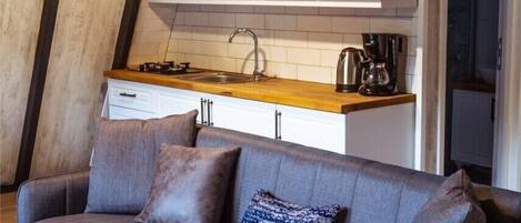 A modern kitchen with white cabinets, a wooden countertop, and a built-in stove.
