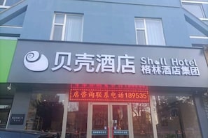 A hotel sign with the name 'Shall Hotel' and a contact phone number.