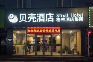 A hotel with a sign indicating it is part of the Sh. Lin Hotel Group.
