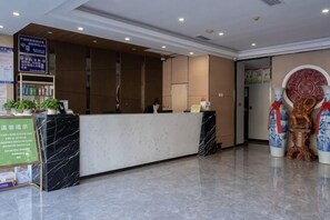 A hotel reception area with a marble floor, a reception desk, and a statue. - GreenTree Shell Hotel (Yantai University Yingchun Street) (Yantai)