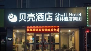 A hotel entrance with a sign reading "Shell Hotel" and "æ ¼æž—é…’åº—é›†å›¢". - GreenTree Shell Hotel (Yantai University Yingchun Street) (Yantai)