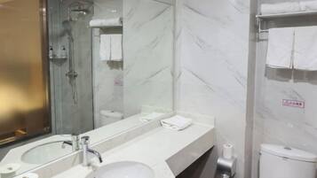 A modern bathroom with a glass-enclosed shower, a large mirror, a white sink, and a toilet.