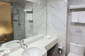 A modern bathroom with a glass-enclosed shower, a large mirror, a white sink, and a toilet. - GreenTree Shell Hotel (Yantai University Yingchun Street) (Yantai)