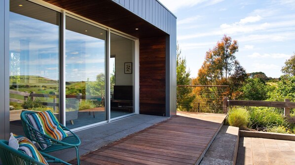 A modern house with a large glass door leading to a deck. - Kirkwood - Pet Friendly - Mid Century - Walking distance to Clunes! (Clunes)