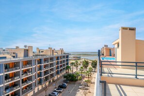 Et hotel med flere etager, altaner, swimmingpool og udsigt til stranden.