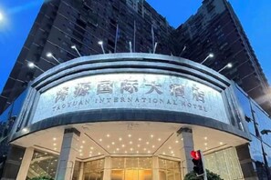 Un hôtel doté d’une façade incurvée et d’une enseigne lumineuse.