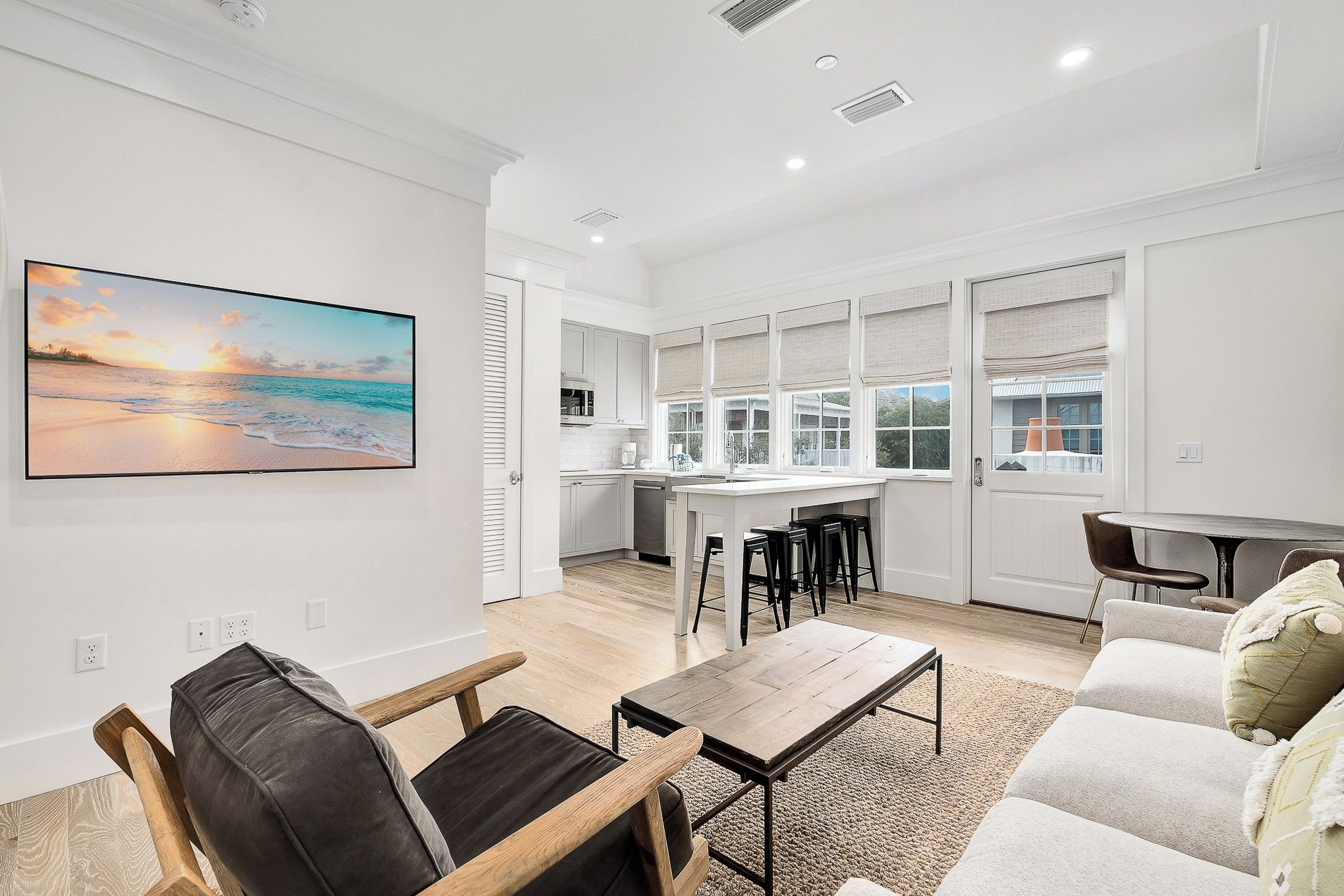 A spacious living area with a wooden coffee table, a sofa, and a kitchen in the background.