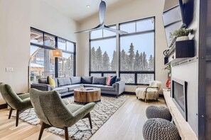 A modern living room with a sectional sofa, round coffee table, and ottomans.