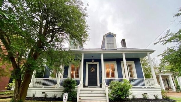 A two-story house with a front porch, a brick pathway, and a large tree. - The Beaumont House (Natchez)