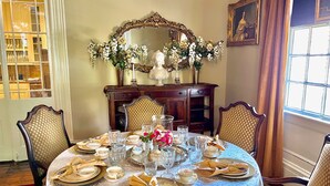 A formal dining room with a round table set for four, surrounded by ornate chairs. - The Beaumont House (Natchez)