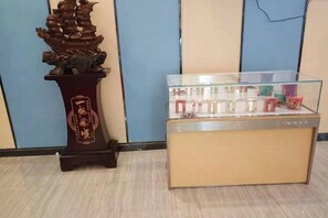 A display case with various items, a decorative ship sculpture, and a plaque with Chinese characters.