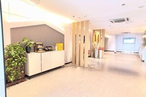 A reception area with a reception desk, potted plants, and a modern interior design. - Citi Home Hotel (Taohua Town Government) (Feixi)