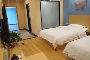 A hotel room with two beds, a TV, a potted plant, and a sliding door. - Citi Home Hotel (Taohua Town Government) (Feixi)