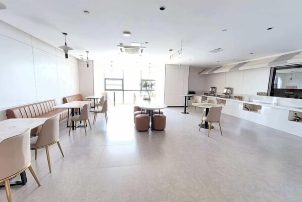 A modern interior with a dining area, kitchen, and seating.