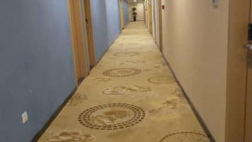 Un pasillo de hotel con pisos alfombrados y puertas a ambos lados.