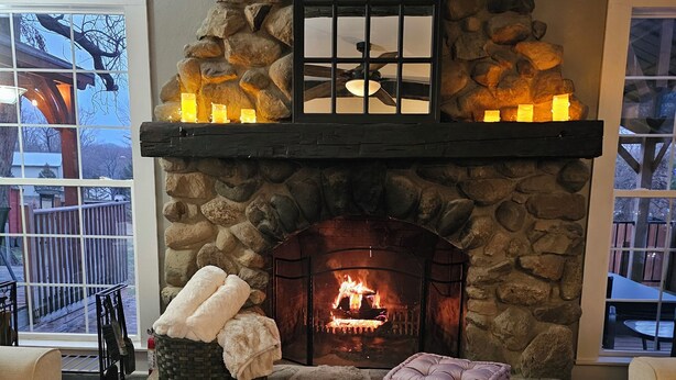 Ein Steinkamin mit Feuer, ein Buch mit dem Titel 'Struggle Well', eine Tasse und ein Tablett mit einer Pflanze.