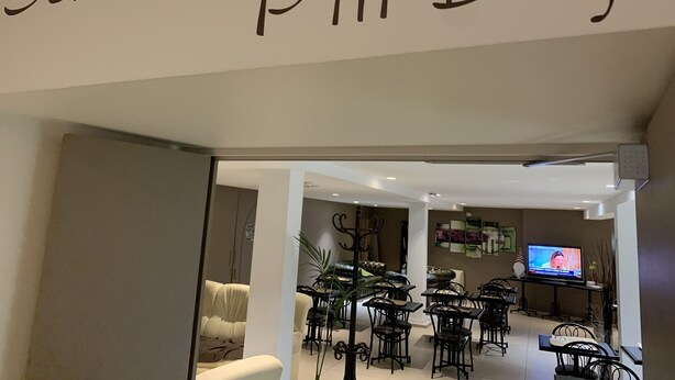 Interior de salón con un letrero que dice 'Salons p'tit Déj'.