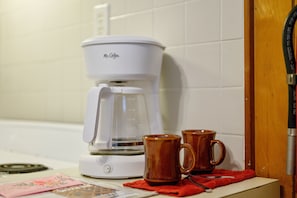 Une machine à café avec deux tasses posées sur une table.