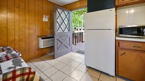 Cocina compacta con refrigerador, microondas y gabinetes de madera.
