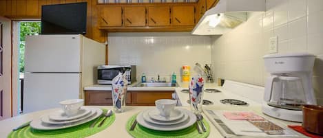 Un four, surface de cuisson, vaisselle et ustensiles