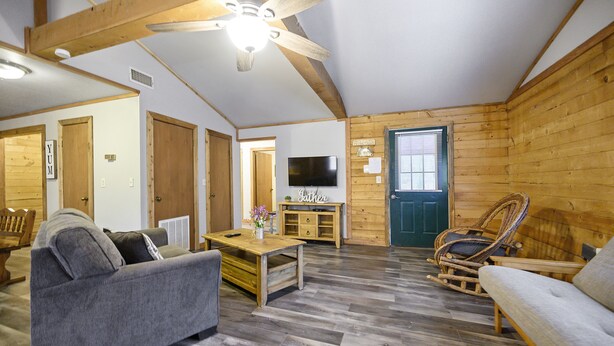 A cozy living room with a wooden ceiling, a television, and a rocking chair. - Crabapple Cove | Sleeps 8 | Porch Swing, Fire Pit & Near Beavers Bend (Broken Bow)