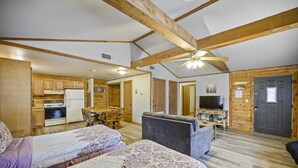 A spacious room with two beds, a dining area, and a kitchen.