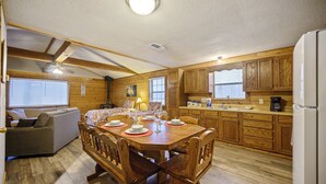 Un interior acogedor de cabaña con comedor, cocina y sala de estar.
